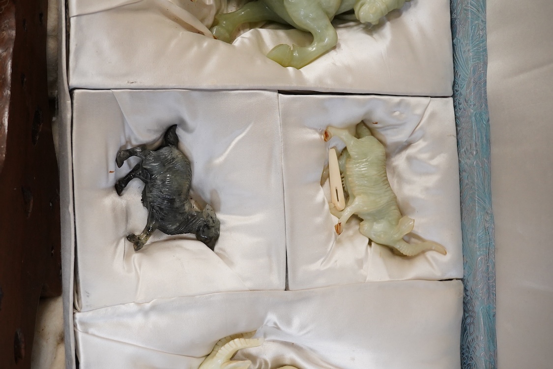 A Chinese silk brocade box containing six Chinese hard stone coloured carved animals and a wooden and metal inlaid stand, largest a horse 19cm wide